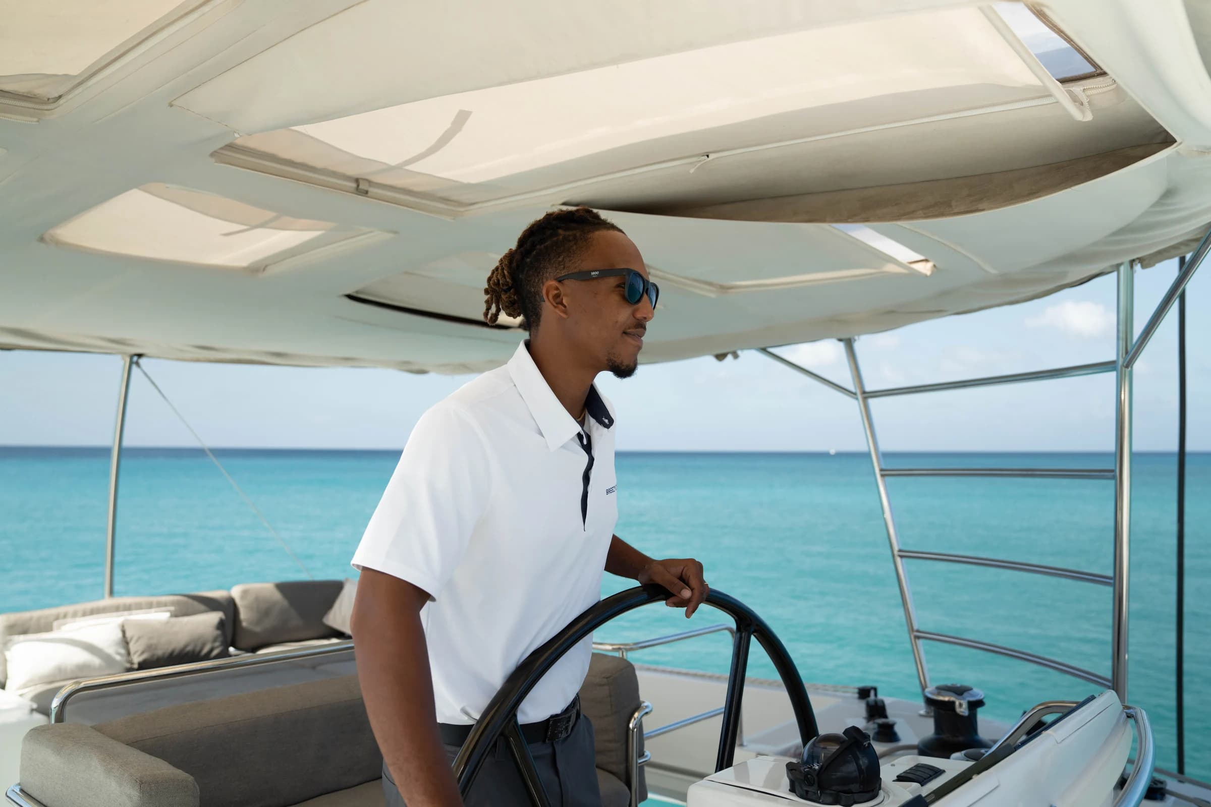 Breezy Days captain at the helm on turquoise water