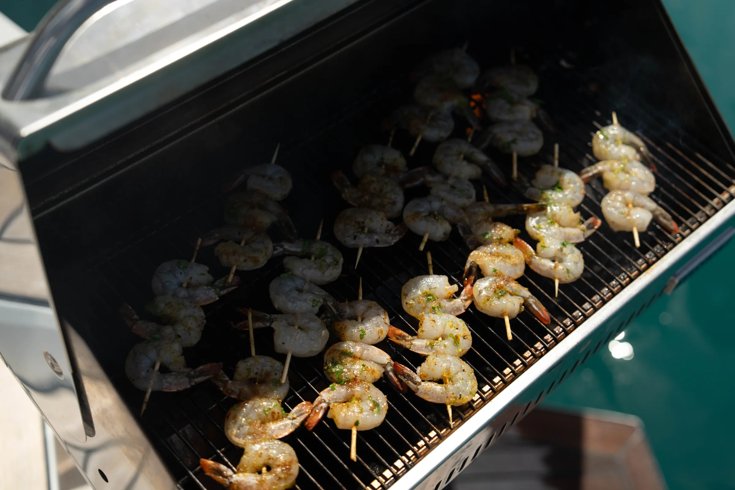 Shrimp skewers grilling on board